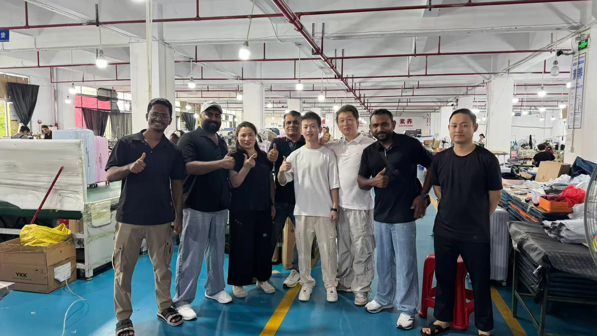 Hongbin factory team with international buyers on the production floor